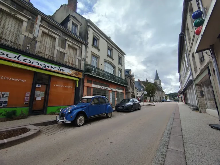 immeuble avec voiture bleue garée devant