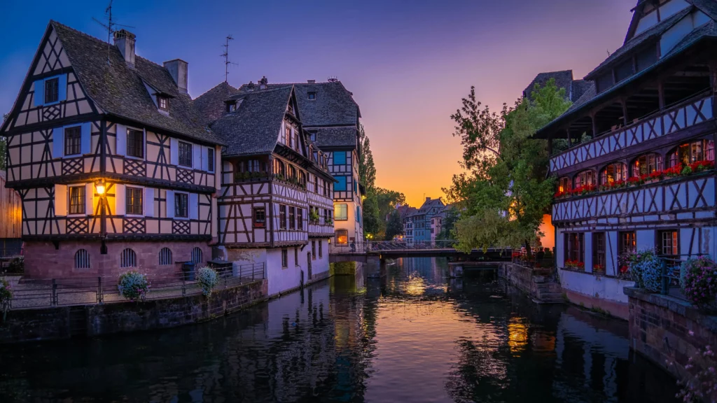 Strasbourg avec un ponton et de l'eau. sur la gauche du ponton il y a une maison à colombage