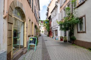 Photo d'une rue à Strasbourg pavée avec des boutiques sur les côtés