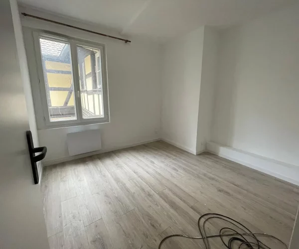 Chambre sans aucun meuble avec parquet stratifié et fenêtres