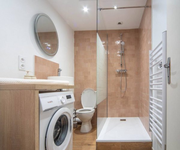 salle de bains avec douche et machine à laver